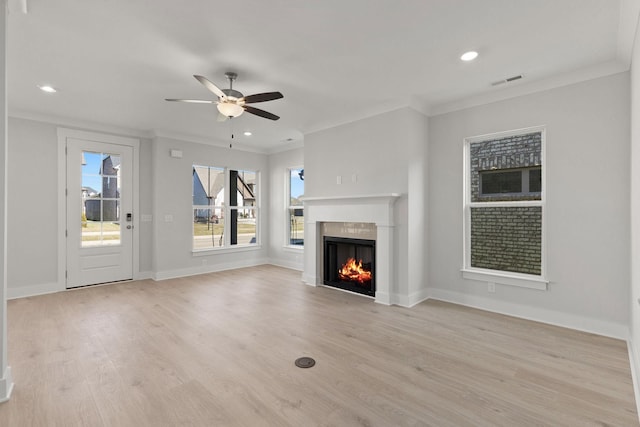 unfurnished living room with ceiling fan, ornamental molding, and light hardwood / wood-style floors