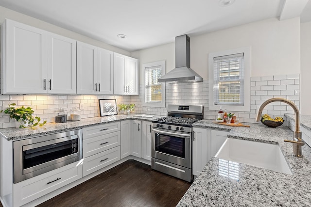 kitchen featuring white cabinets, stainless steel appliances, sink, and exhaust hood