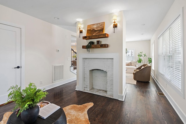 living room featuring dark wood-type flooring and a fireplace