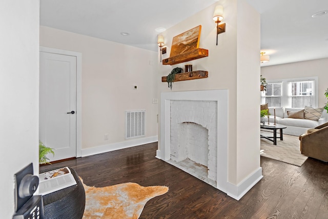 living room with dark wood-type flooring and a fireplace