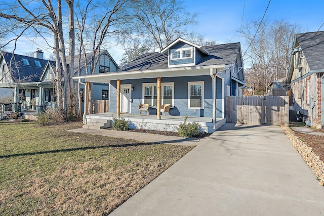 bungalow-style home with central AC, covered porch, and a front yard