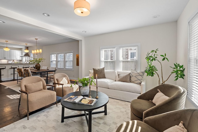 living room featuring light wood-type flooring, baseboards, and a chandelier