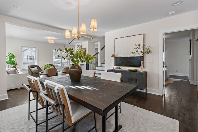 dining room with dark wood-type flooring and a notable chandelier