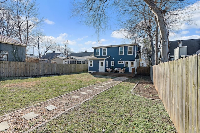 back of house featuring a wooden deck and a lawn