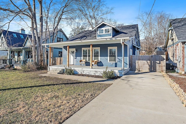 bungalow with a porch and a front lawn