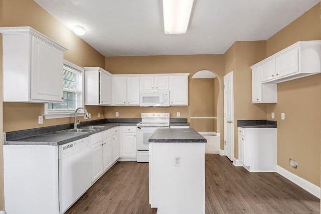 kitchen featuring white cabinetry, white appliances, a center island, and sink