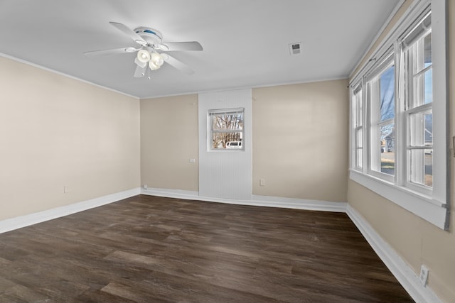 empty room featuring crown molding, dark hardwood / wood-style floors, and ceiling fan