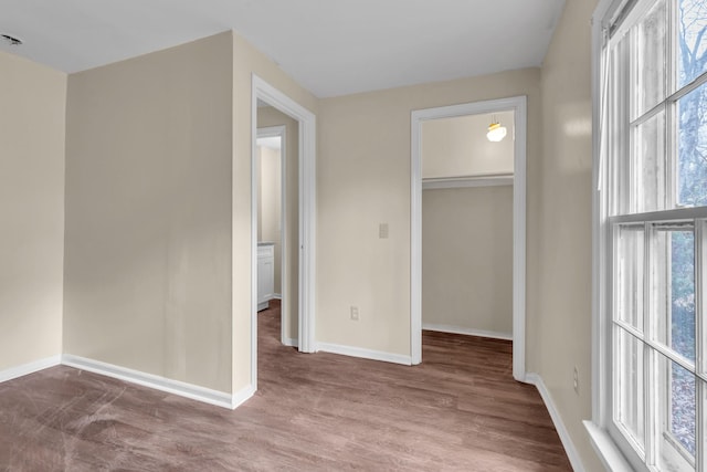 unfurnished bedroom with hardwood / wood-style flooring, a closet, and a spacious closet