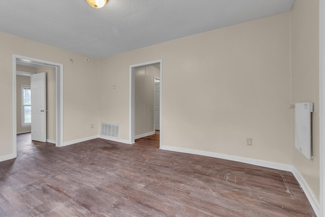 unfurnished room with hardwood / wood-style floors and a textured ceiling