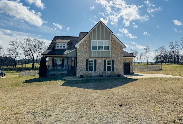 view of front of home featuring a porch, a garage, and a front yard