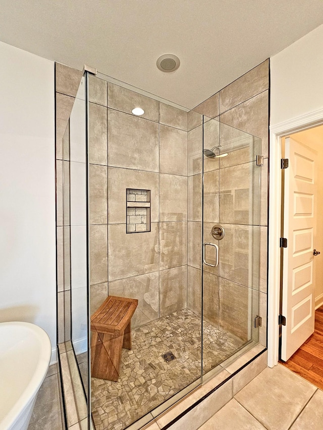 bathroom with shower with separate bathtub and tile patterned floors