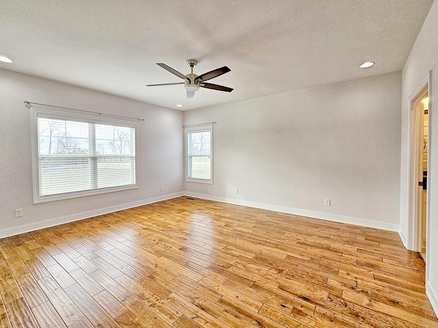 empty room with a textured ceiling, light hardwood / wood-style floors, and ceiling fan