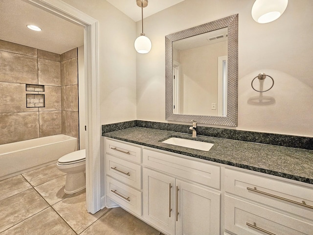 full bathroom with tile patterned flooring, vanity, tiled shower / bath combo, and toilet