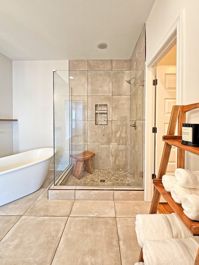 bathroom with tile patterned floors and shower with separate bathtub