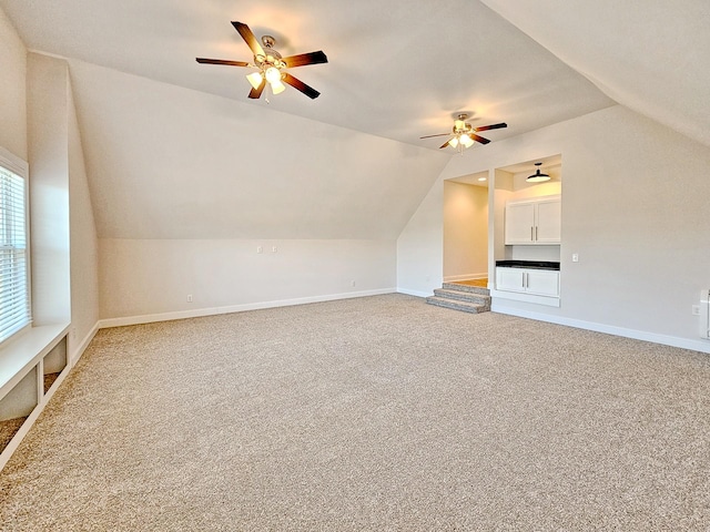 bonus room with vaulted ceiling, carpet flooring, and ceiling fan