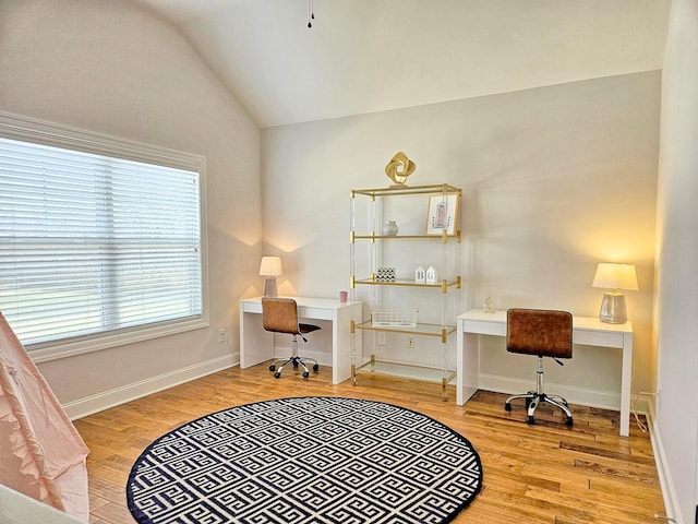 office space with vaulted ceiling and light wood-type flooring