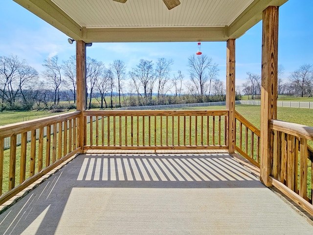 deck featuring ceiling fan and a lawn