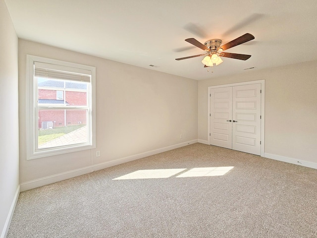 unfurnished bedroom with ceiling fan, a closet, and carpet