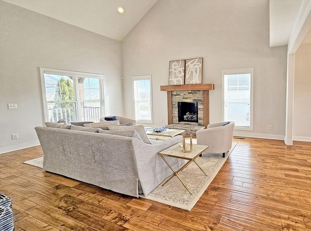 living room featuring a fireplace, wood-type flooring, and high vaulted ceiling