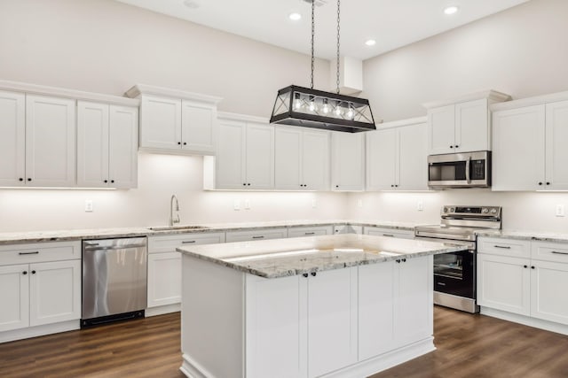 kitchen featuring decorative light fixtures, stainless steel appliances, and white cabinets