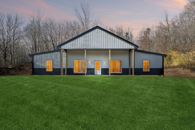 property exterior at dusk featuring a lawn