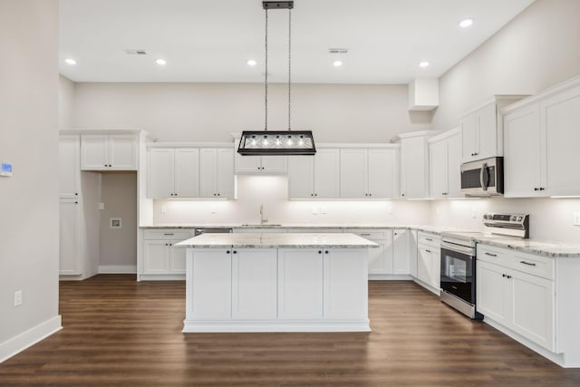 kitchen with appliances with stainless steel finishes, a kitchen island, and white cabinets