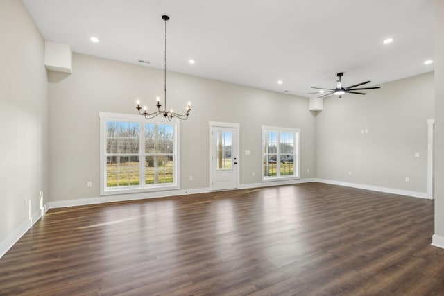 unfurnished living room featuring ceiling fan with notable chandelier and dark wood-type flooring