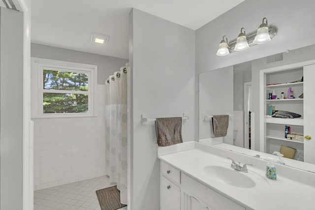 bathroom with vanity, curtained shower, and built in shelves