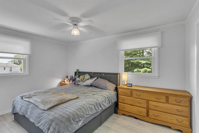 bedroom featuring crown molding, ceiling fan, and light hardwood / wood-style flooring