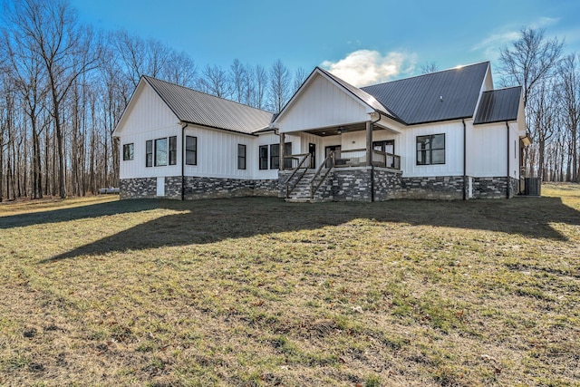 modern inspired farmhouse with central AC unit, covered porch, and a front lawn