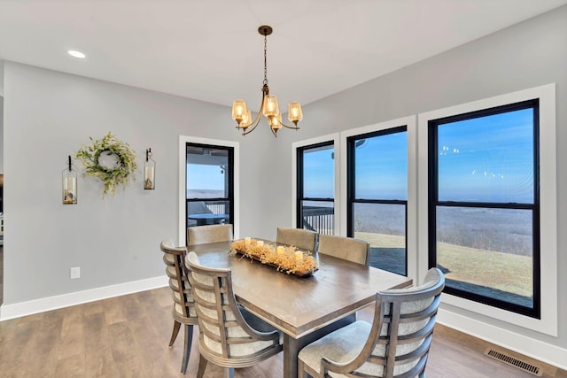 dining room with wood-type flooring and a notable chandelier