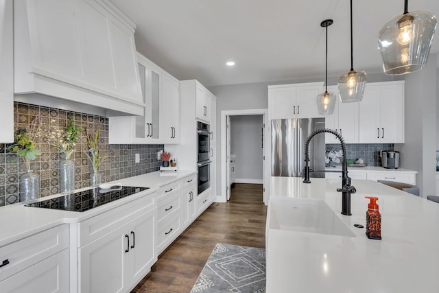 kitchen with decorative light fixtures, white cabinetry, dark hardwood / wood-style flooring, stainless steel appliances, and custom range hood