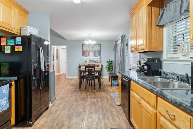 kitchen featuring pendant lighting, sink, an inviting chandelier, wood-type flooring, and black appliances