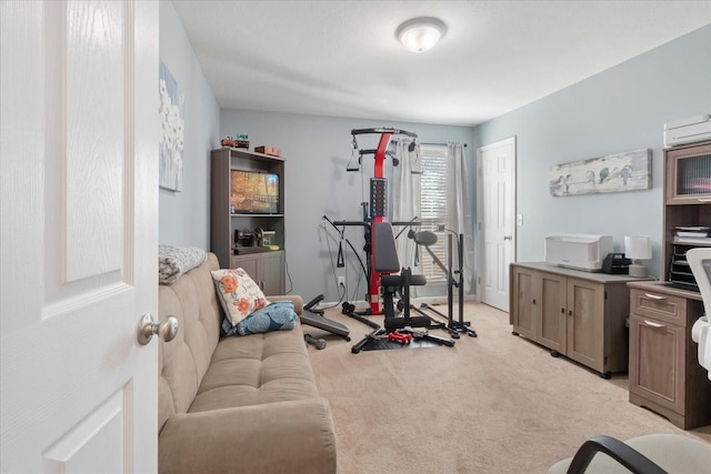 workout room featuring a wall mounted air conditioner and light colored carpet