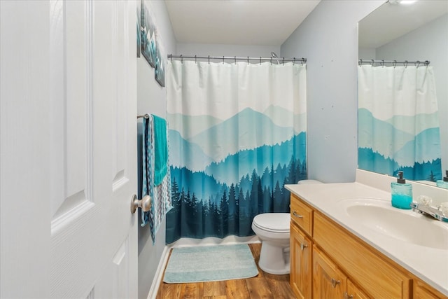 bathroom with hardwood / wood-style flooring, vanity, a shower with curtain, and toilet