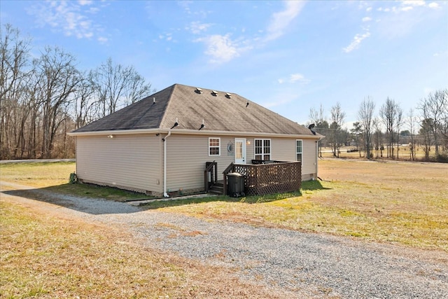 view of side of property with a deck and a lawn