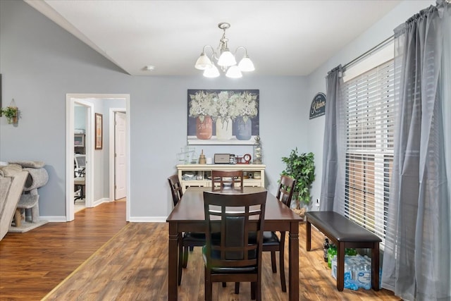 dining space with hardwood / wood-style flooring and a notable chandelier