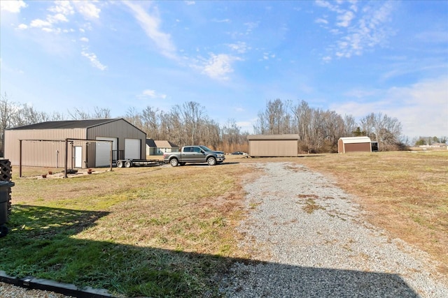 view of yard featuring a garage and an outbuilding