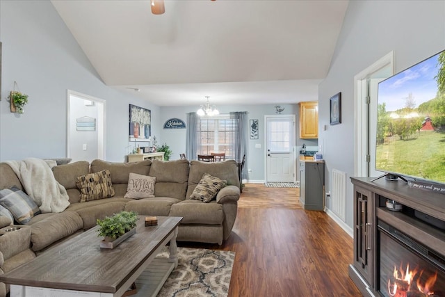 living room with dark hardwood / wood-style floors, an inviting chandelier, and high vaulted ceiling