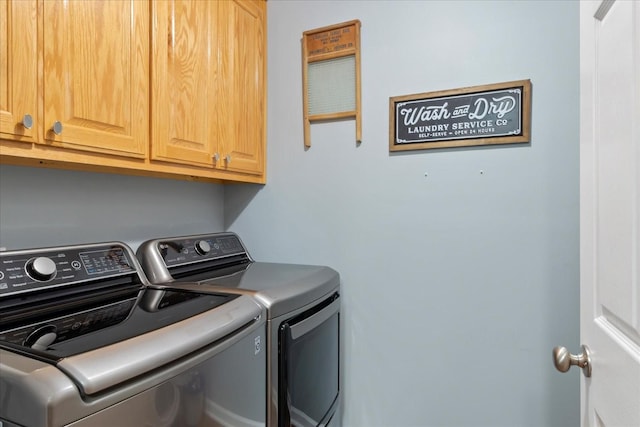 washroom with separate washer and dryer and cabinets