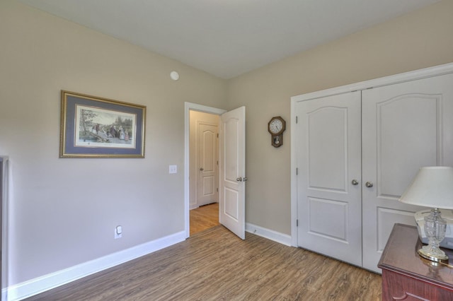 unfurnished bedroom with wood-type flooring and a closet