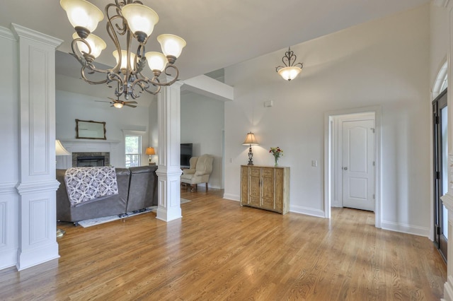 interior space with decorative columns, ceiling fan, and light hardwood / wood-style flooring