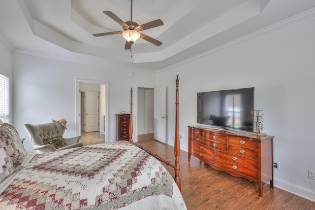 bedroom with light hardwood / wood-style flooring, ornamental molding, a raised ceiling, and ceiling fan