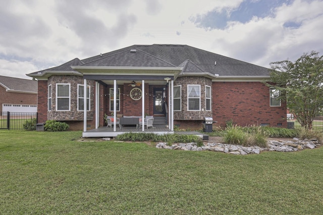 rear view of house with outdoor lounge area, ceiling fan, and a lawn