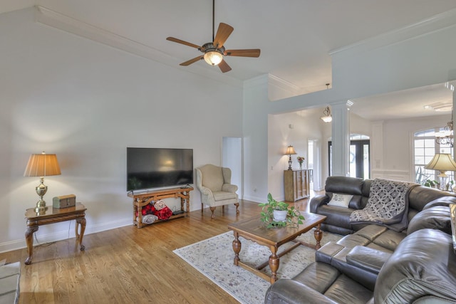 living room with crown molding, ceiling fan, decorative columns, and light wood-type flooring