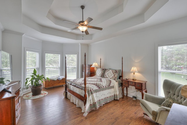 bedroom featuring crown molding, a raised ceiling, and hardwood / wood-style floors