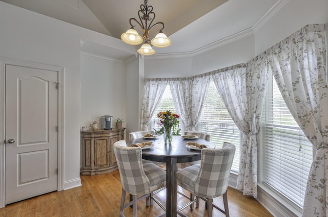 dining area featuring crown molding, a notable chandelier, and light hardwood / wood-style floors