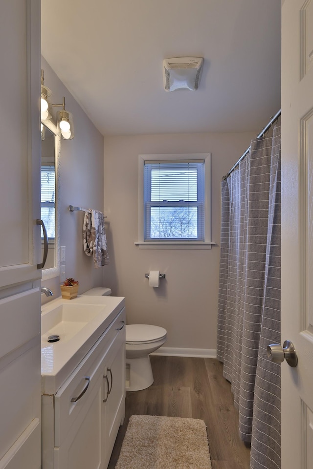 bathroom with hardwood / wood-style flooring, vanity, toilet, and a shower with curtain