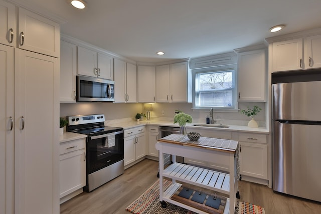 kitchen with sink, white cabinets, and appliances with stainless steel finishes