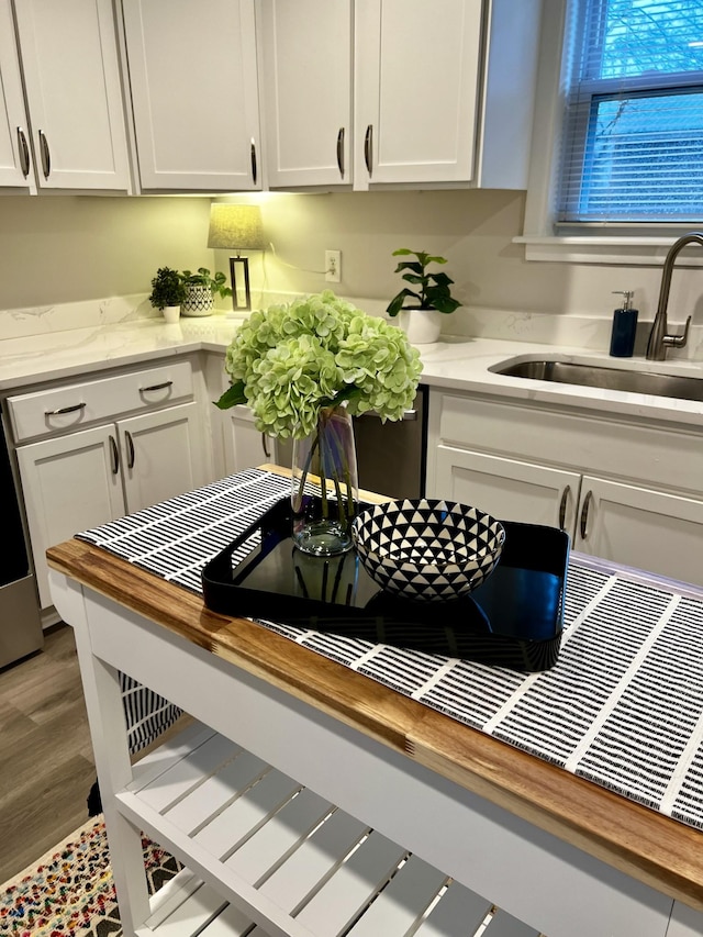 kitchen featuring white cabinetry, sink, and butcher block countertops